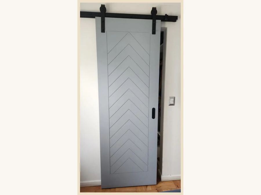 Puerta corredera MDF desnudo para pintura con canterías y riel a la vista